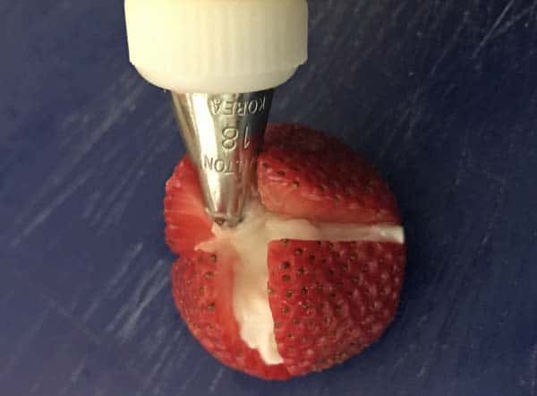 Pipe cream filling in strawberries