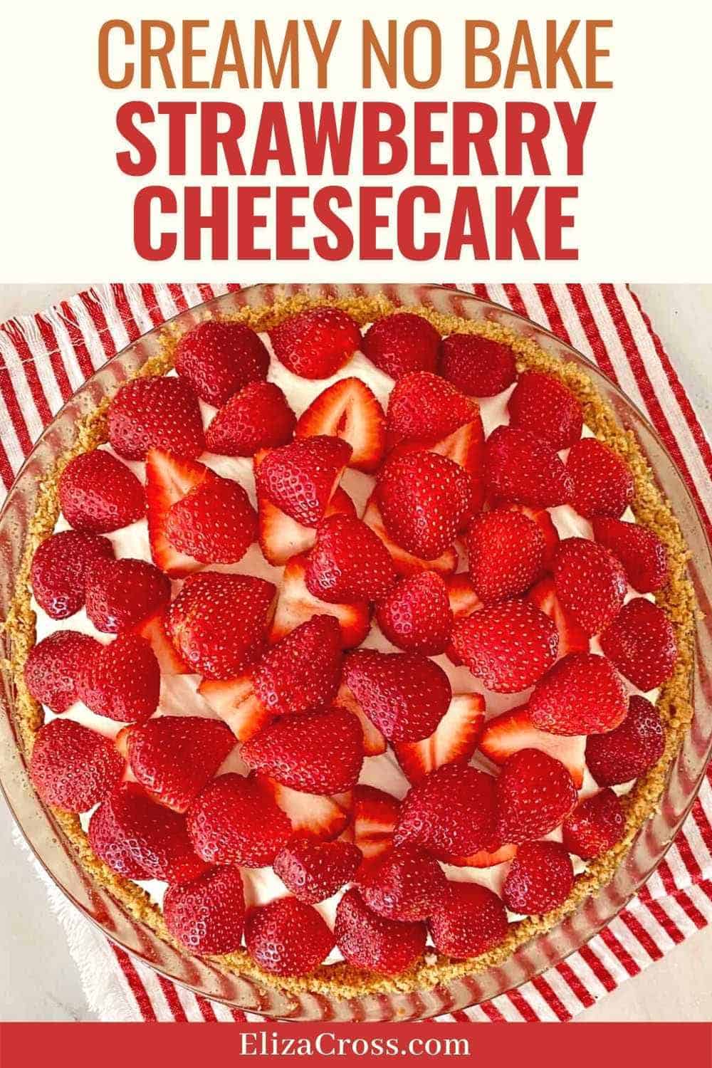 Looking down on a prepared no bake cheesecake with strawberries on a read and white striped napkin.